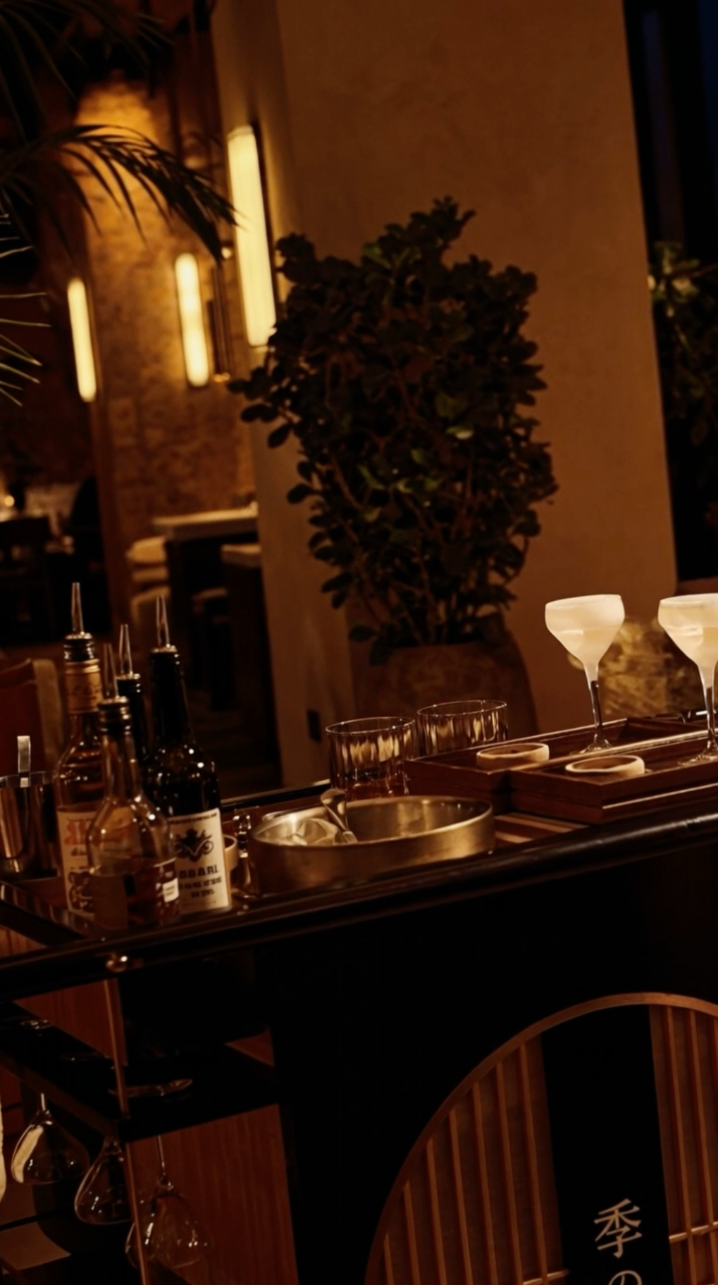 Elegant evening bar cart service in a dimly lit hospitality setting
