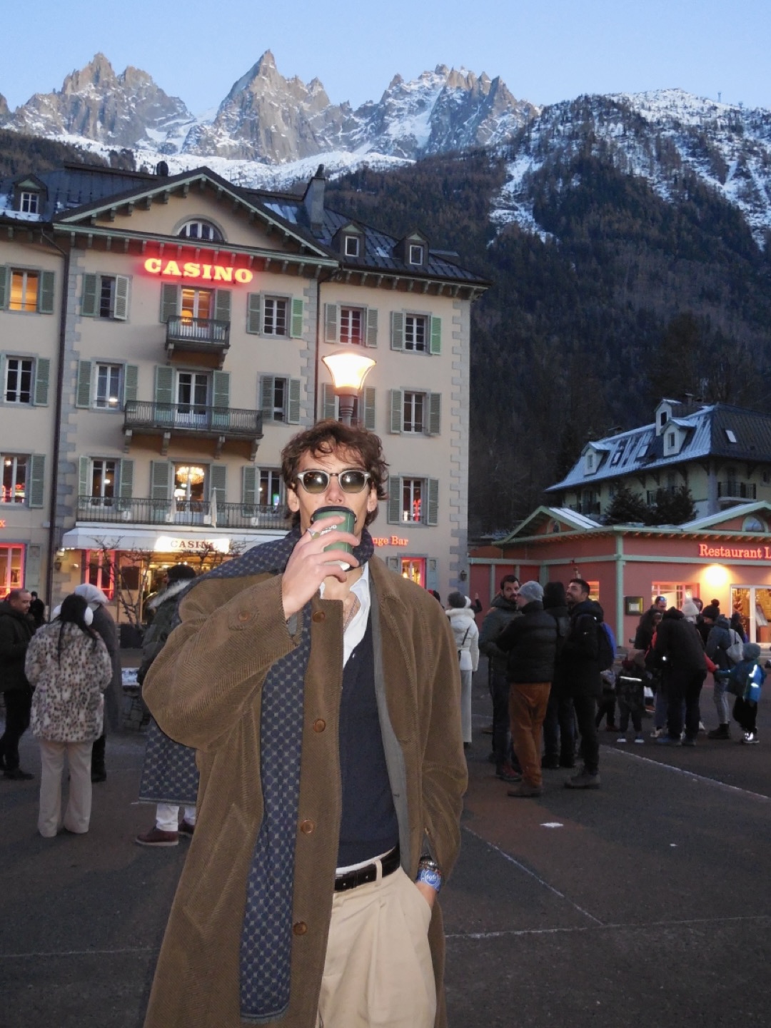 Artist sipping espresso in Chamonix with the Alps behind