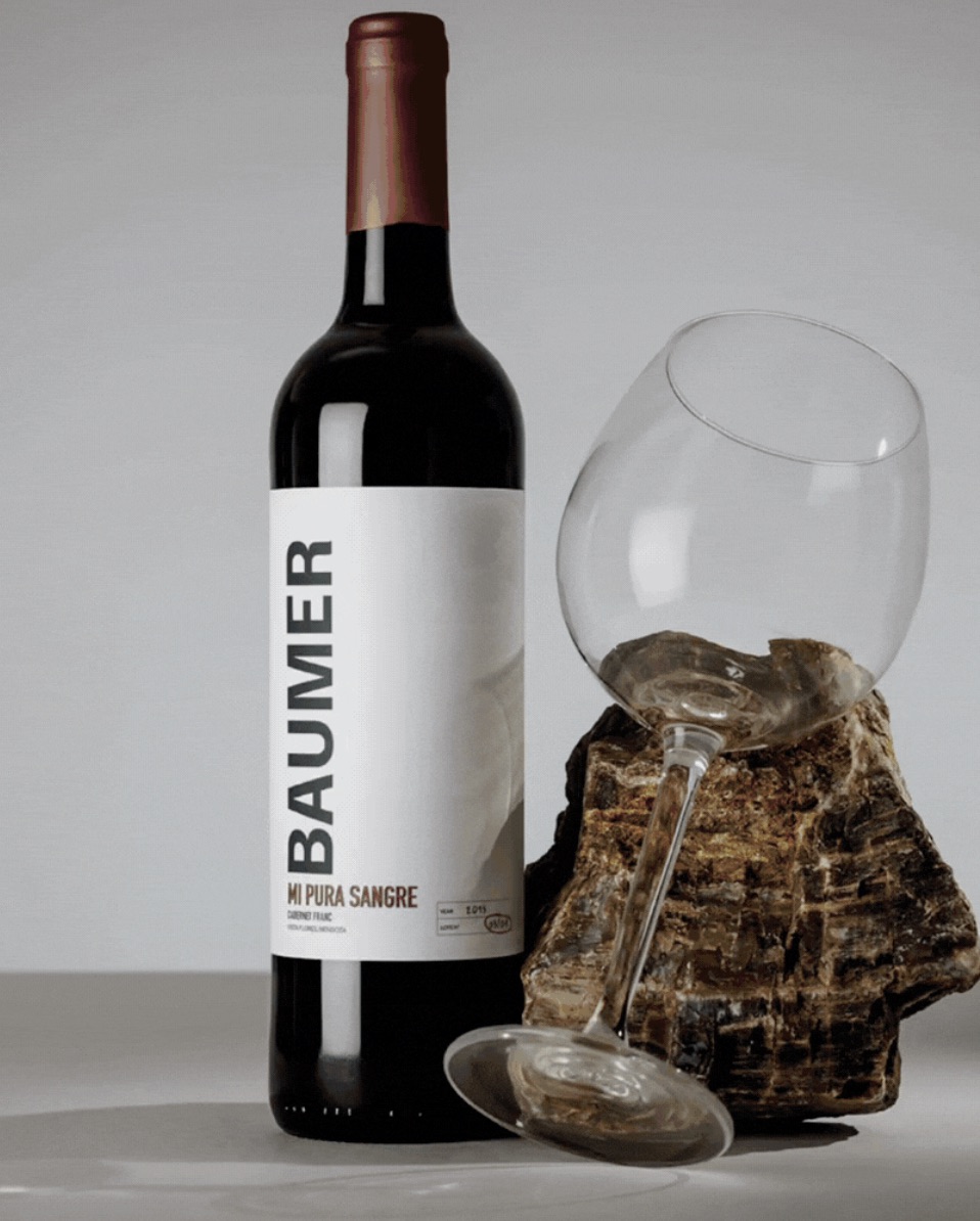 Baumer Mi Pura Sangre Cabernet Franc red wine bottle with glass on petrified wood